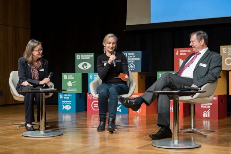 Nachhaltigkeitstagung 2018: Nachhaltigkeit first; drei Menschen tauschen sich während einer Podiumsdiskussion auf der Bühne aus
