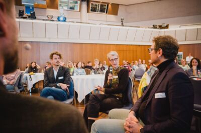 Bayerische Nachhaltigkeitstagung 2023: Nachhaltigkeit in Zeiten knapper Kassen; Teilnehmende tauschen sich im Stuhlkreis der Fishbowl-Diskussion aus