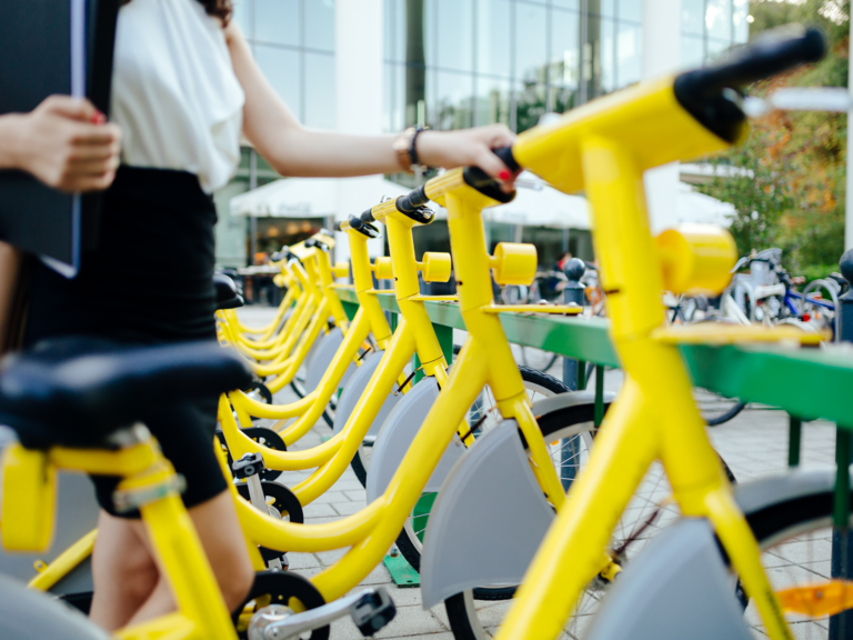 Viele gelbe Fahrräder stehen in einer Reihe an einem Fahrradständer