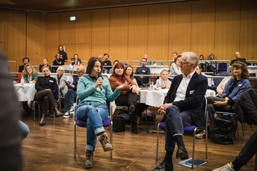 Bayerische Nachhaltigkeitstagung 2022 Nachhaltigkeit und Klimaschutz – notwendiger denn je!: Teilnehmende sitzen in einem Stuhlkreis bei der Fishbowl-Diskussion und tauschen sich aus