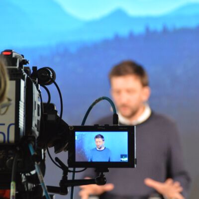 Bayerische Nachhaltigkeitstagung 2020: Online #bayernnachhaltig - jetzt erst recht!: Referent steht auf der Bühne und wird von einer Kamera gefilmt
